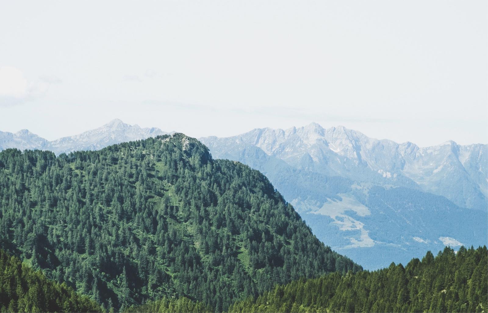 Photo of rolling green mountains a blue sky